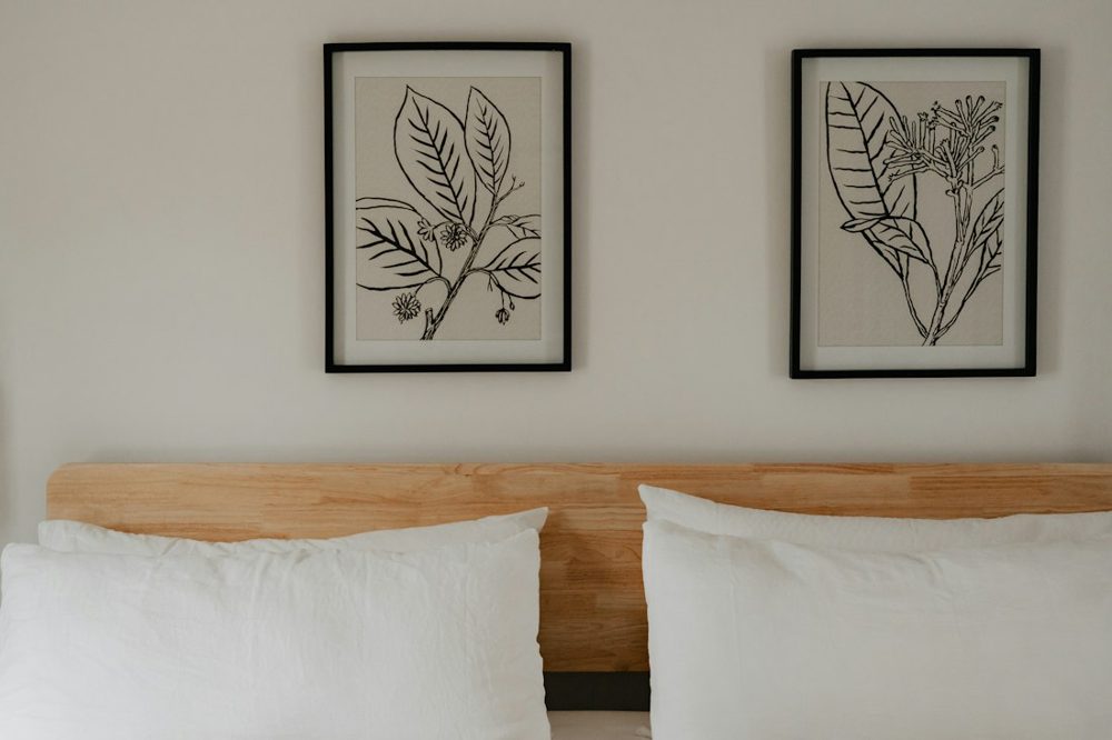 A bed with two framed pictures above it