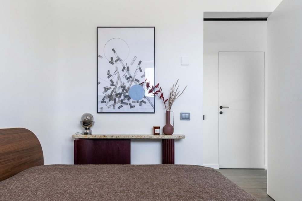 Contemporary bedroom interior with bed, console, and wall art