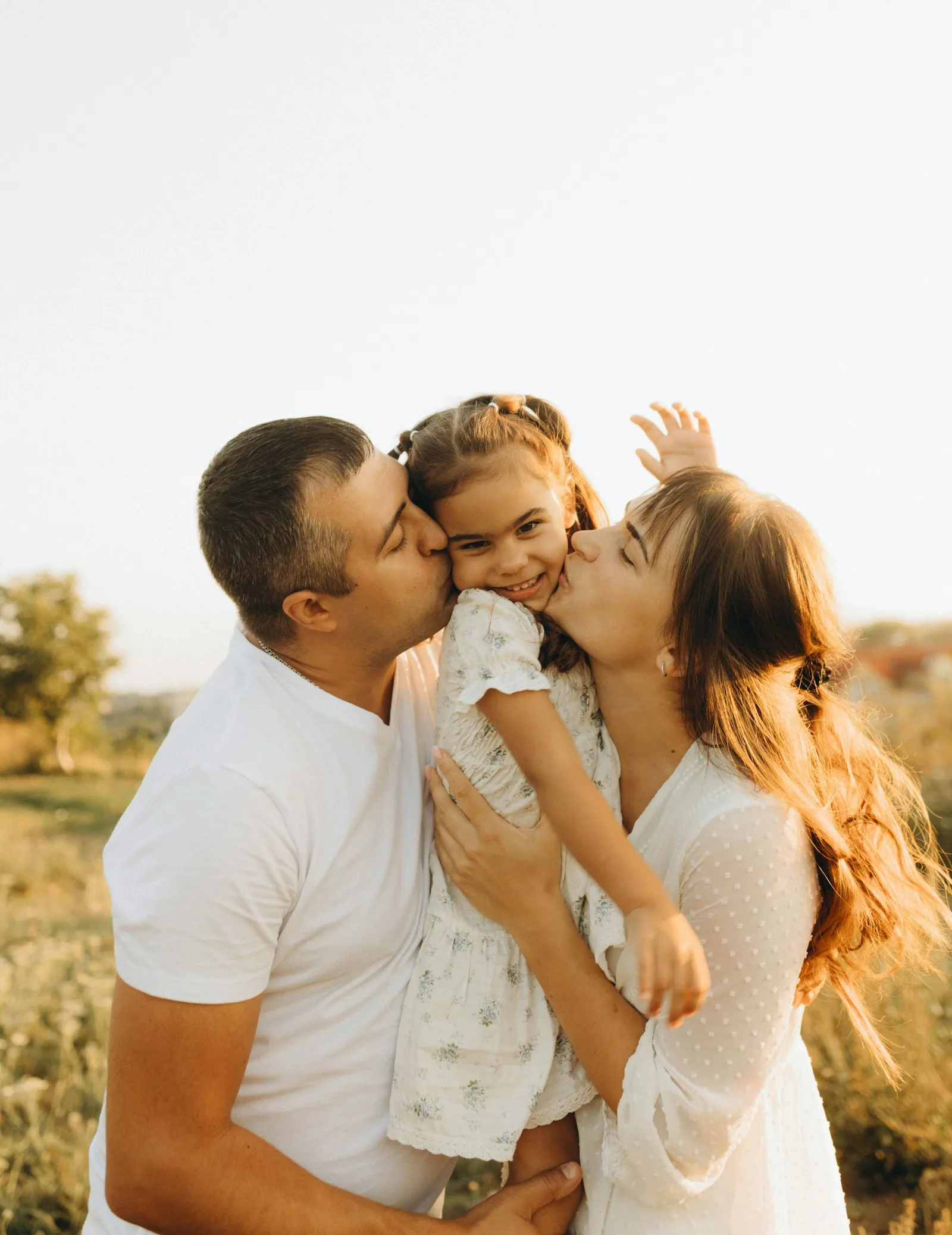 Father kissing his laughing daughter