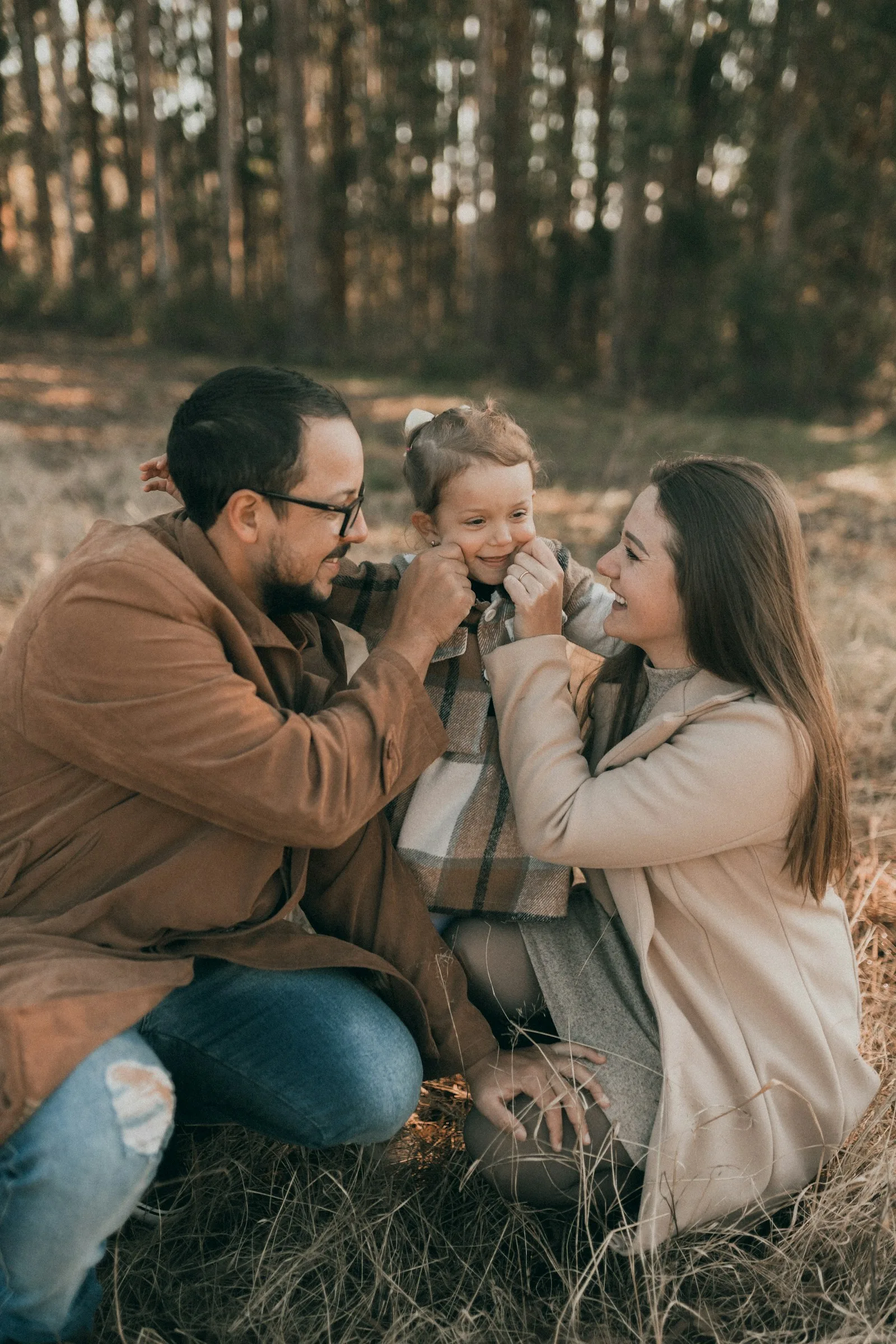Parents kissing their small daughter outdoors