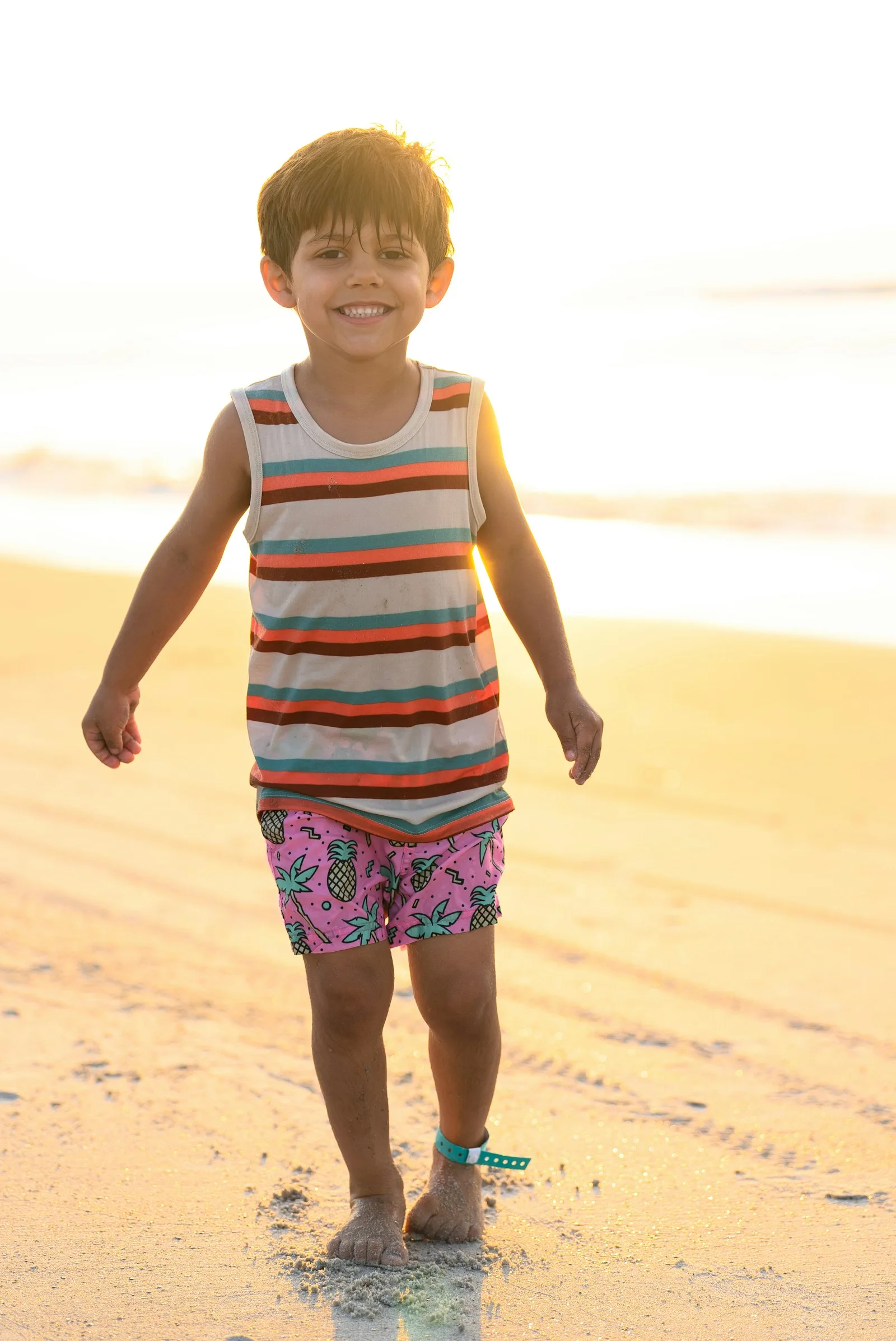Boy walking along the beach in evening light