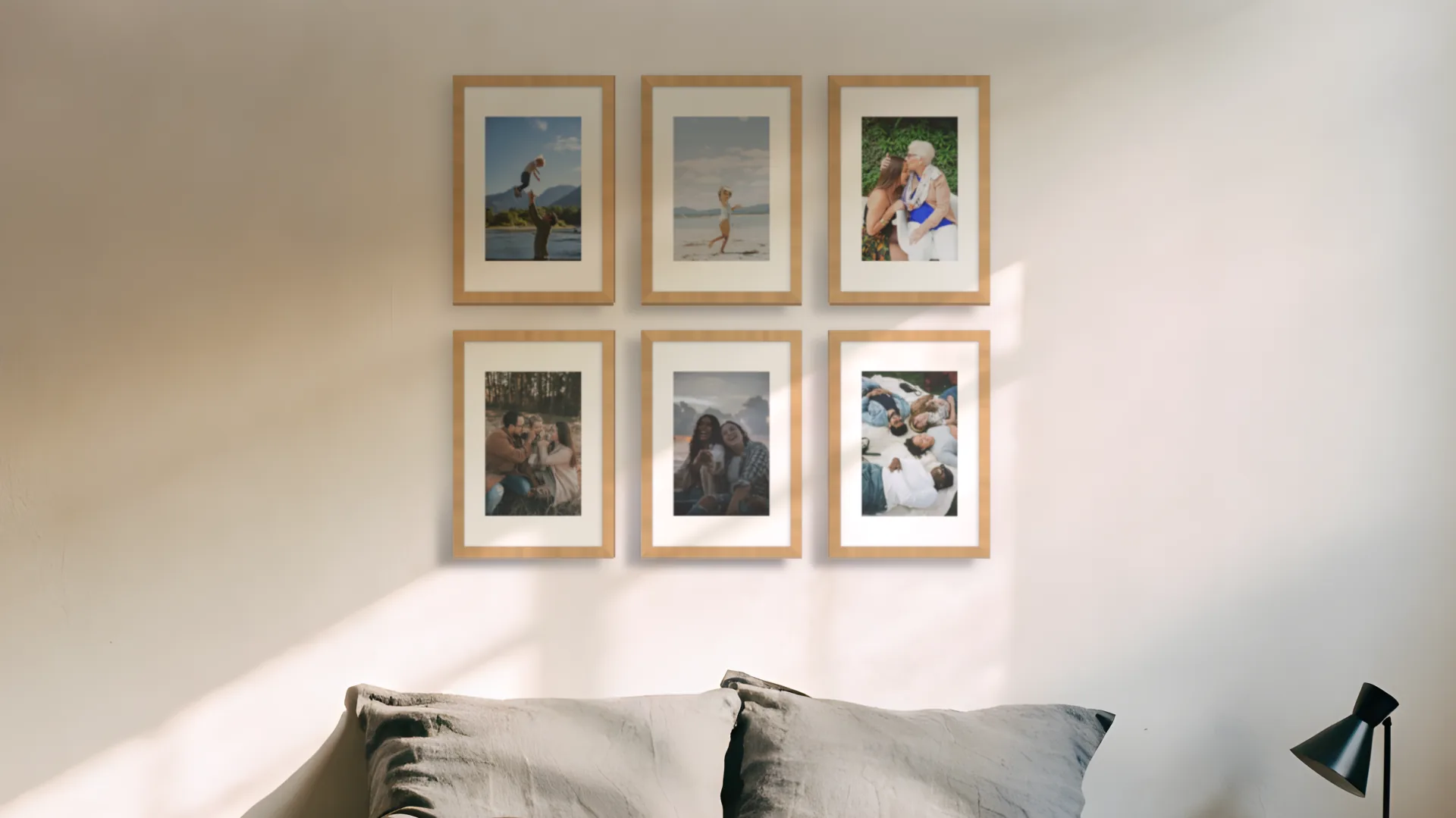 Six family photos in oak frames in a two by three grid above a bed in a bedroom