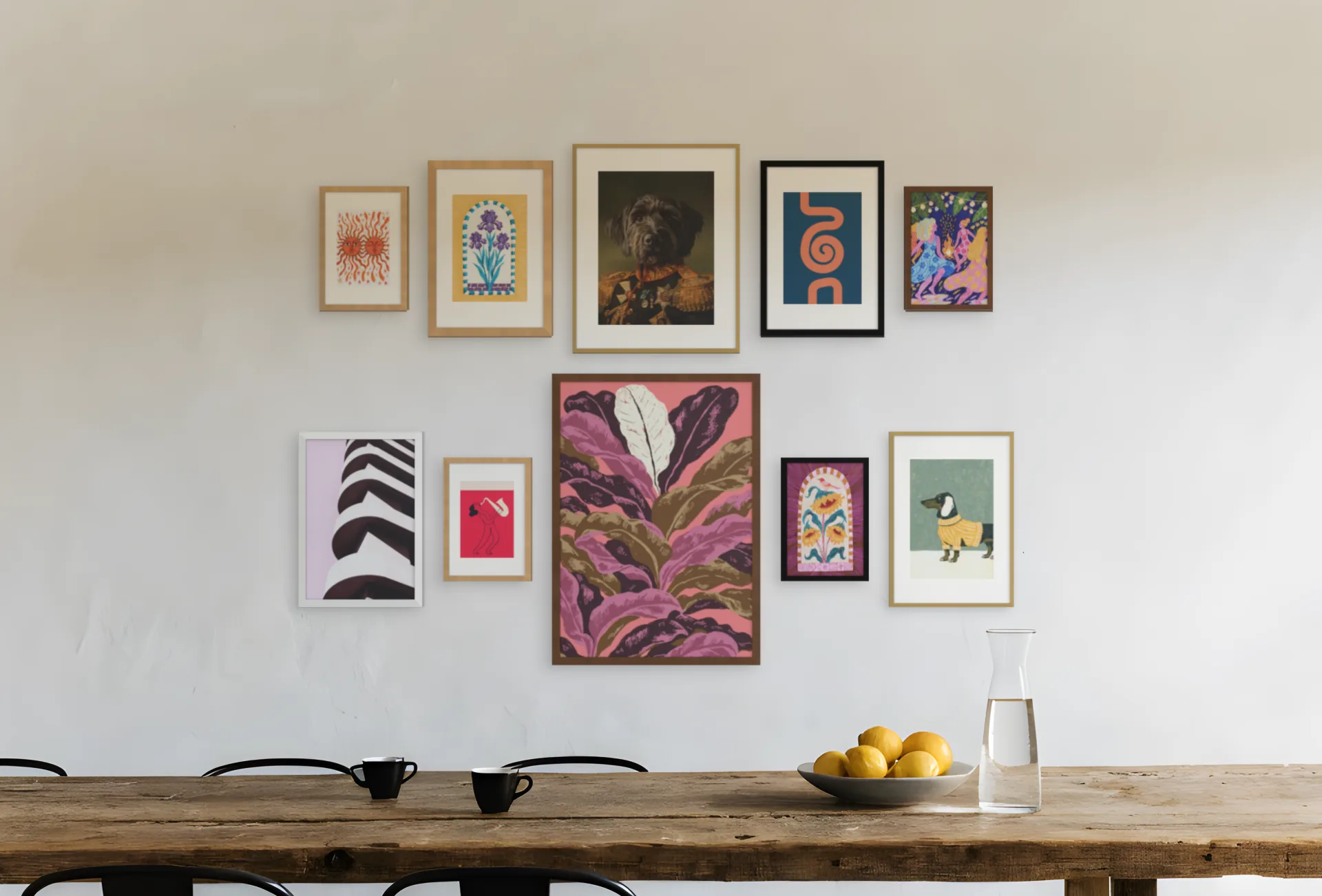 A gallery wall planned for one room: ten framed prints in a salon arrangement above a dining table in a dining room