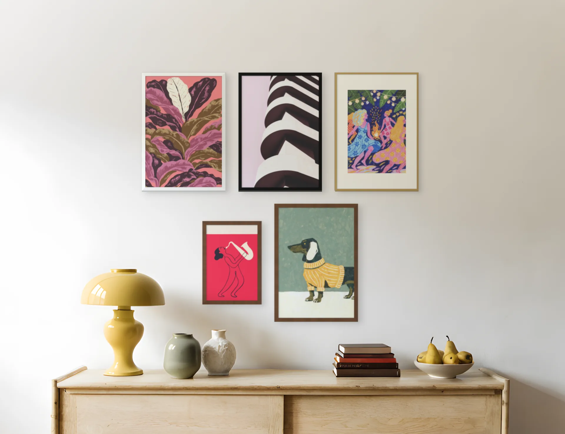 A gallery wall layout: five frames of mixed sizes above a sideboard