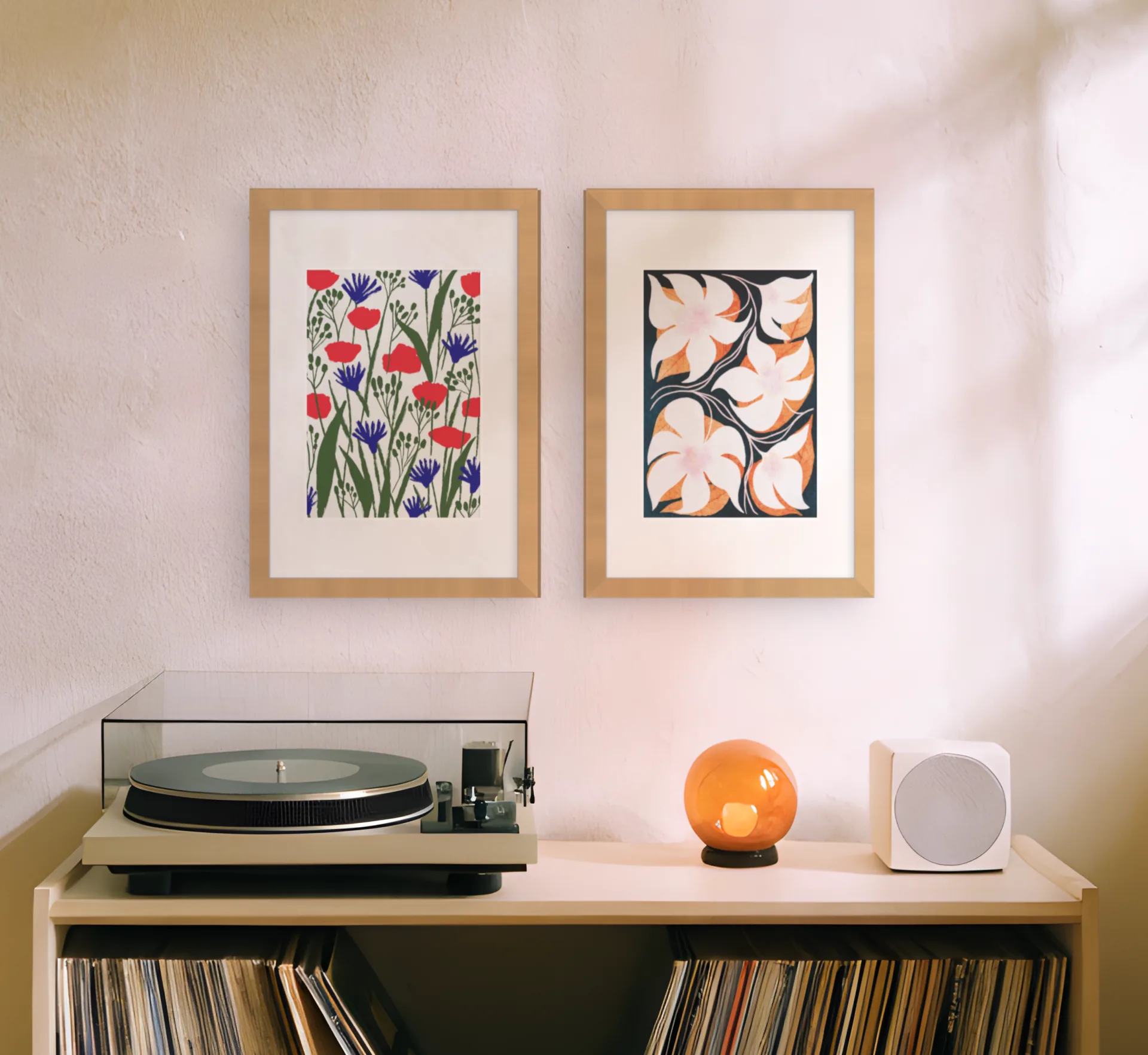 Two framed prints placed above a record unit on a photo of a living room wall