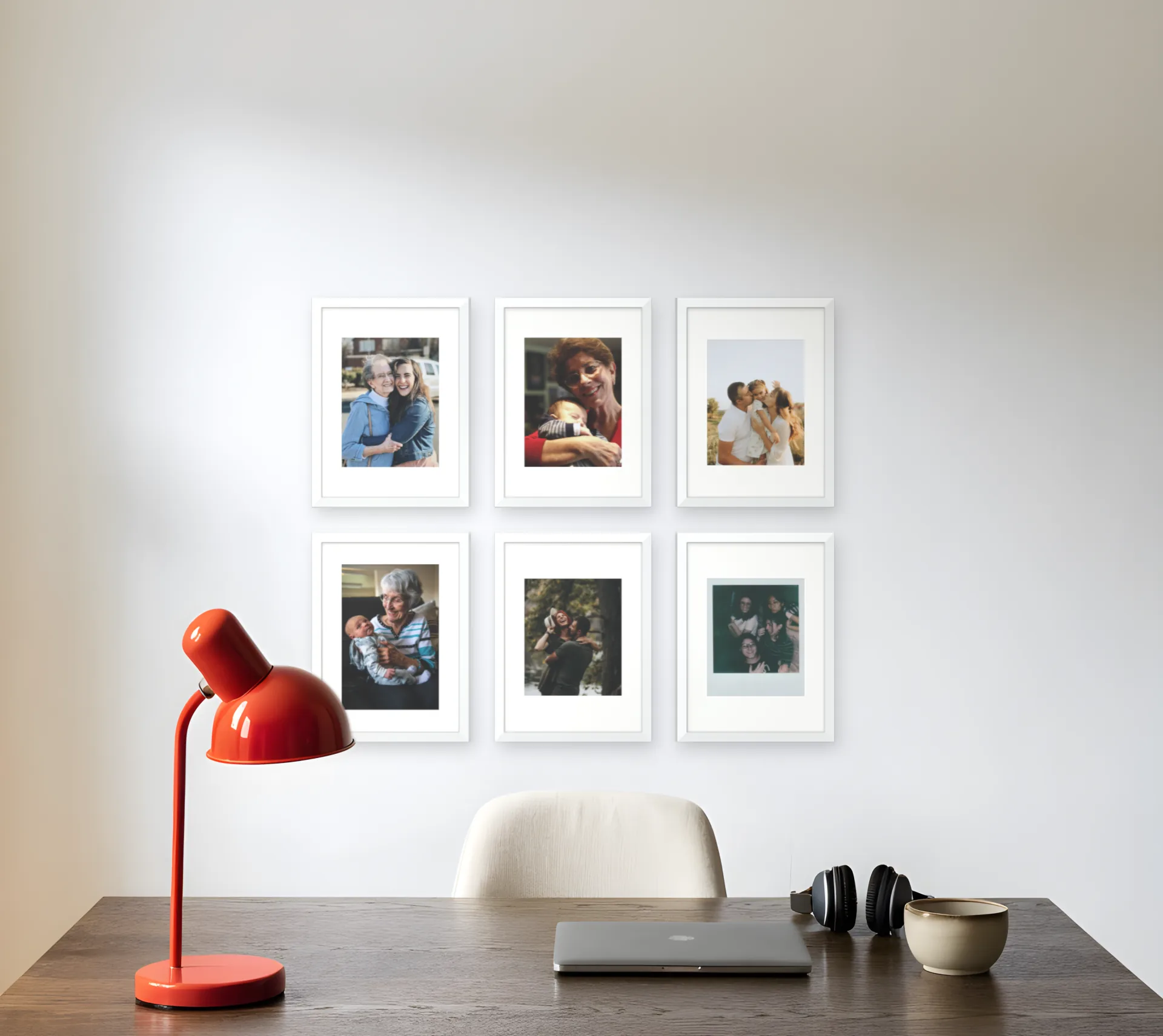 Six family photos in matching white frames in a two by three grid above a desk in a home office