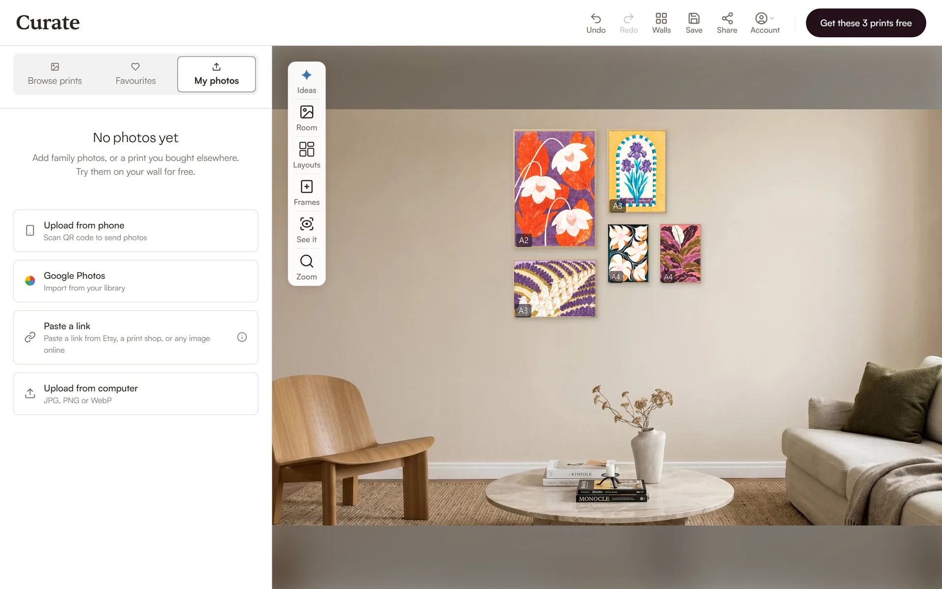 The Curate planner on a laptop with five prints on a living room wall