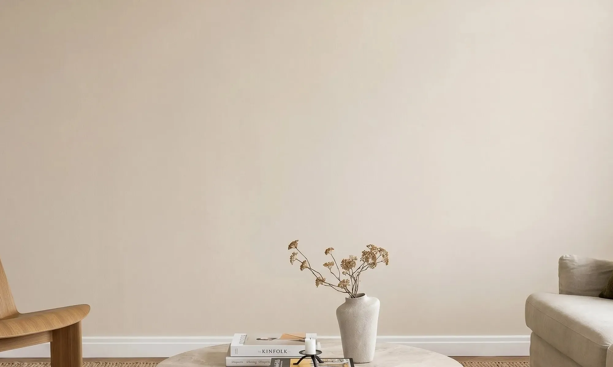 An empty wall, and a phone held up to it showing the same wall with five prints hung in AR