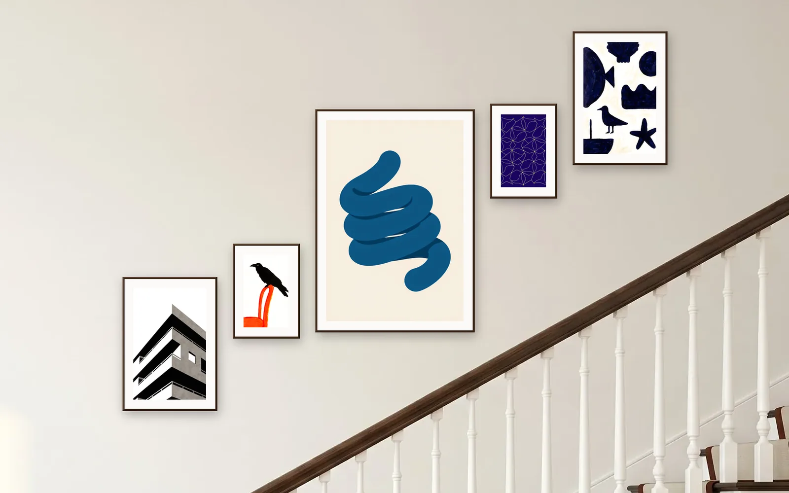 Staircase gallery wall layout: five prints in dark wood frames climbing with the stairs
