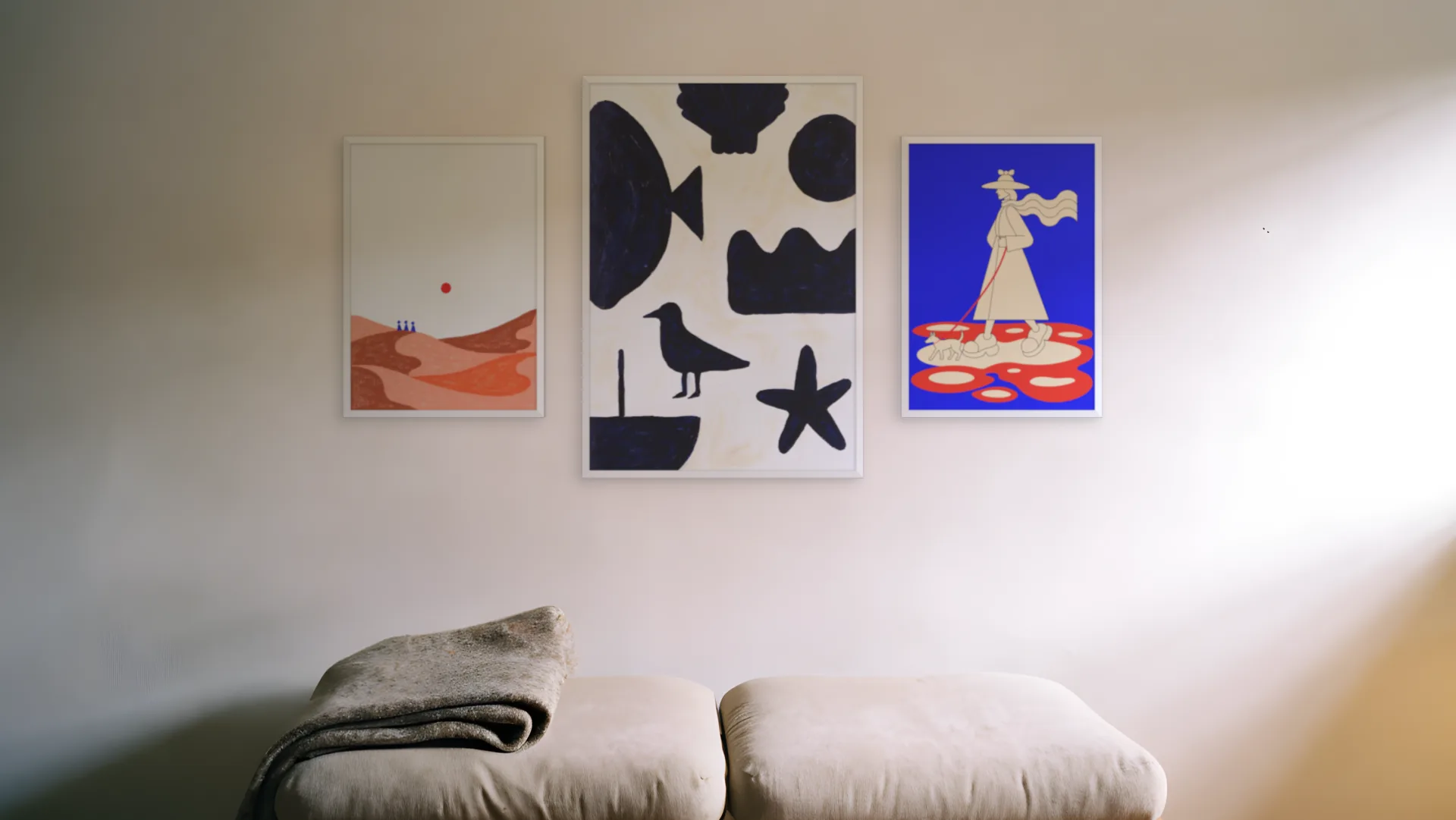 Coastal gallery wall idea: three prints in white frames in a hero trio layout above a bench in a reading nook.