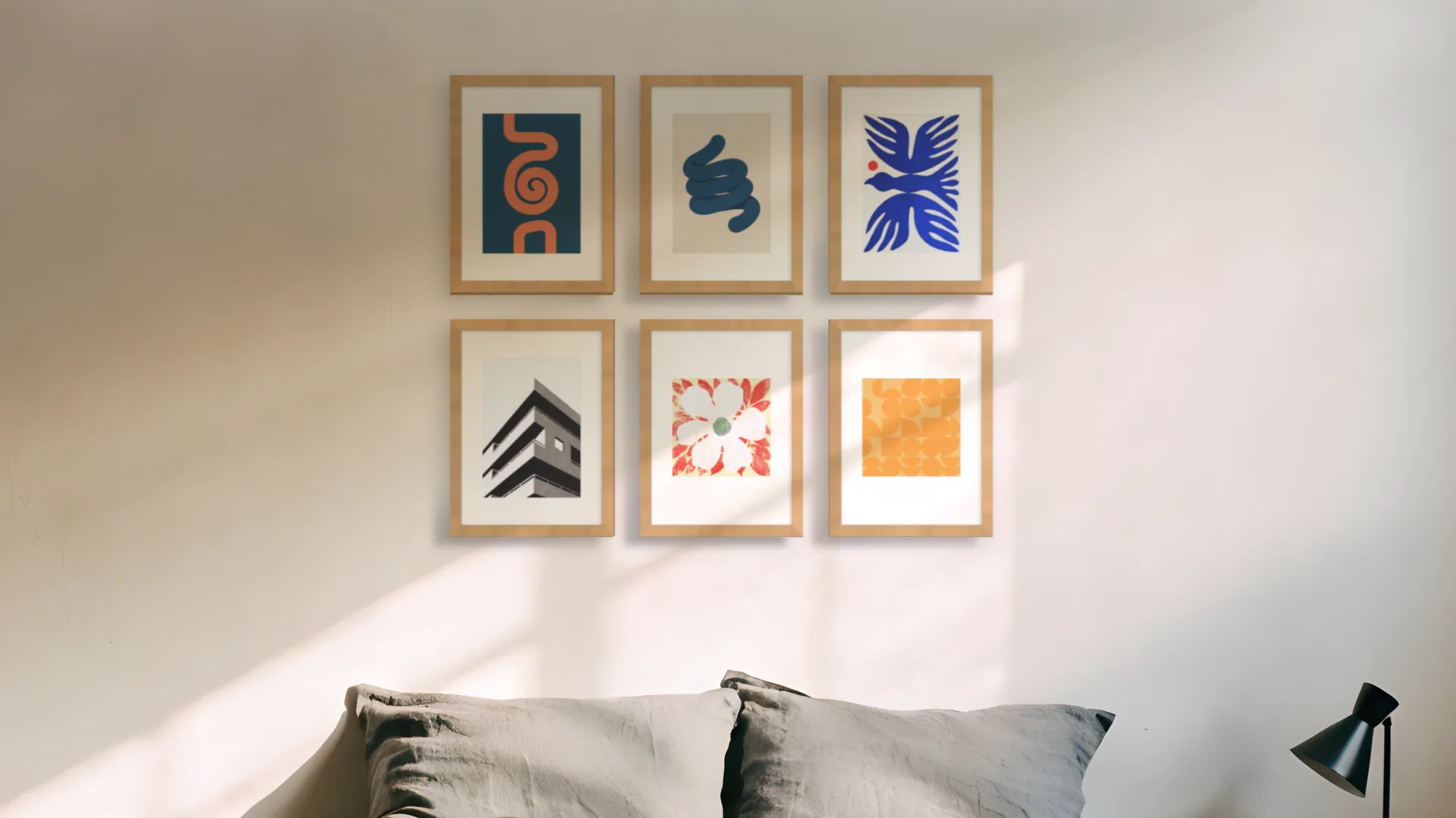 Mid-century gallery wall idea: six prints in oak frames in a two by three grid above a bed in a bedroom.