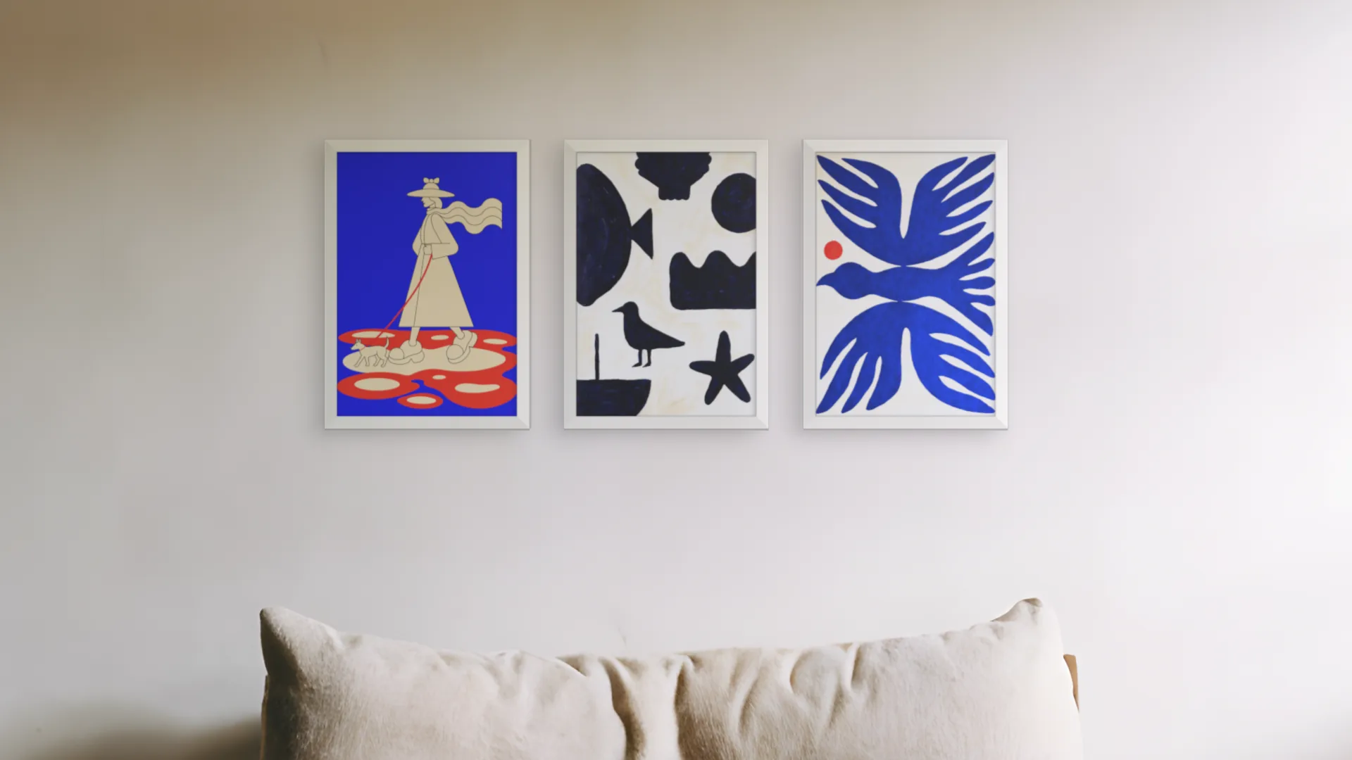 Nursery gallery wall idea: three prints in white frames in a row above an armchair in a reading nook.
