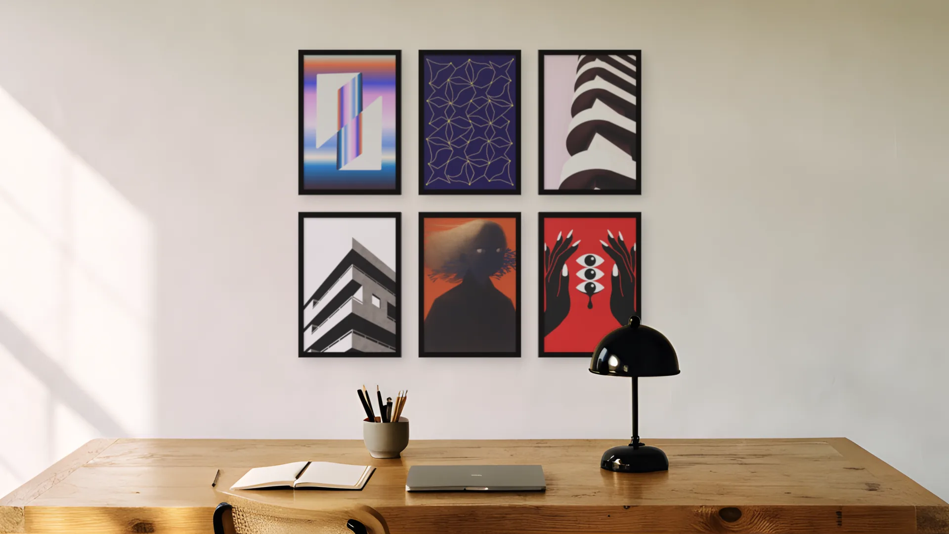 Home office gallery wall idea: six prints in black frames in a two by three grid above a desk in a home office.