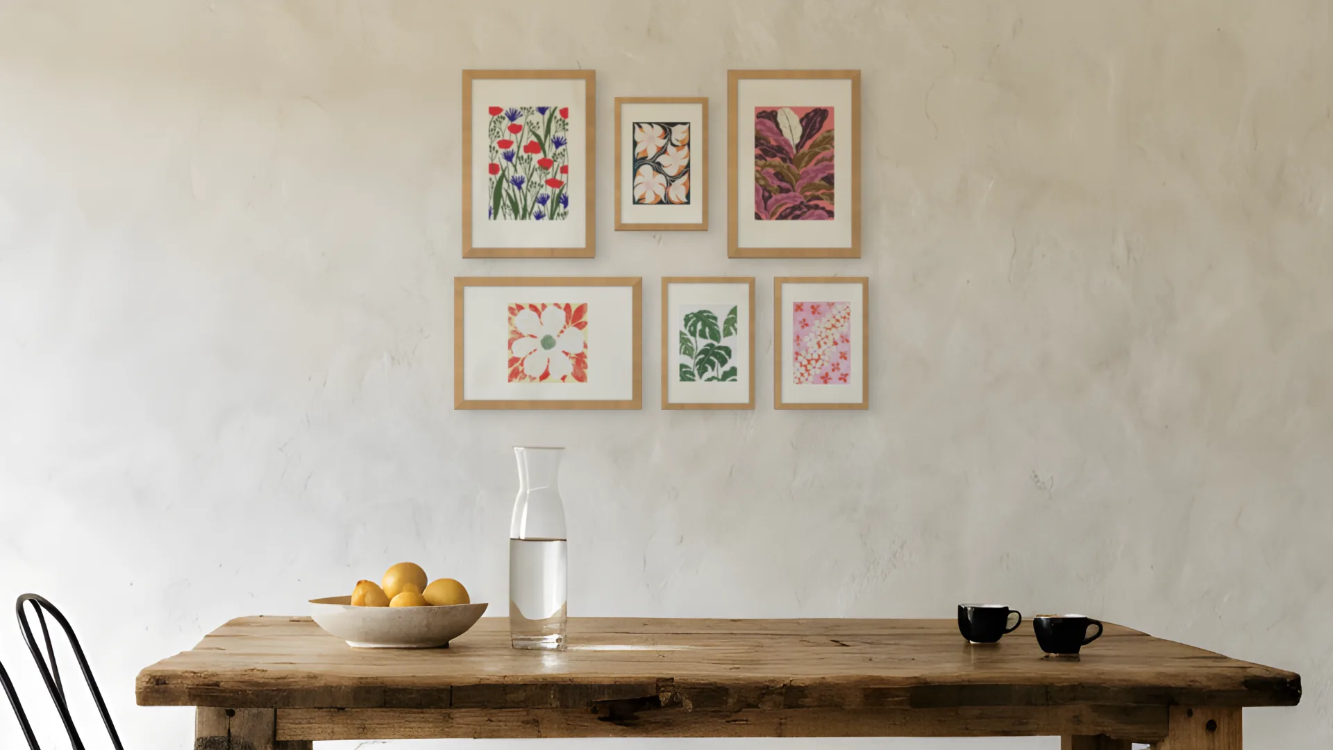 Botanical gallery wall idea: six prints in oak frames in a salon arrangement above a dining table in a dining room.