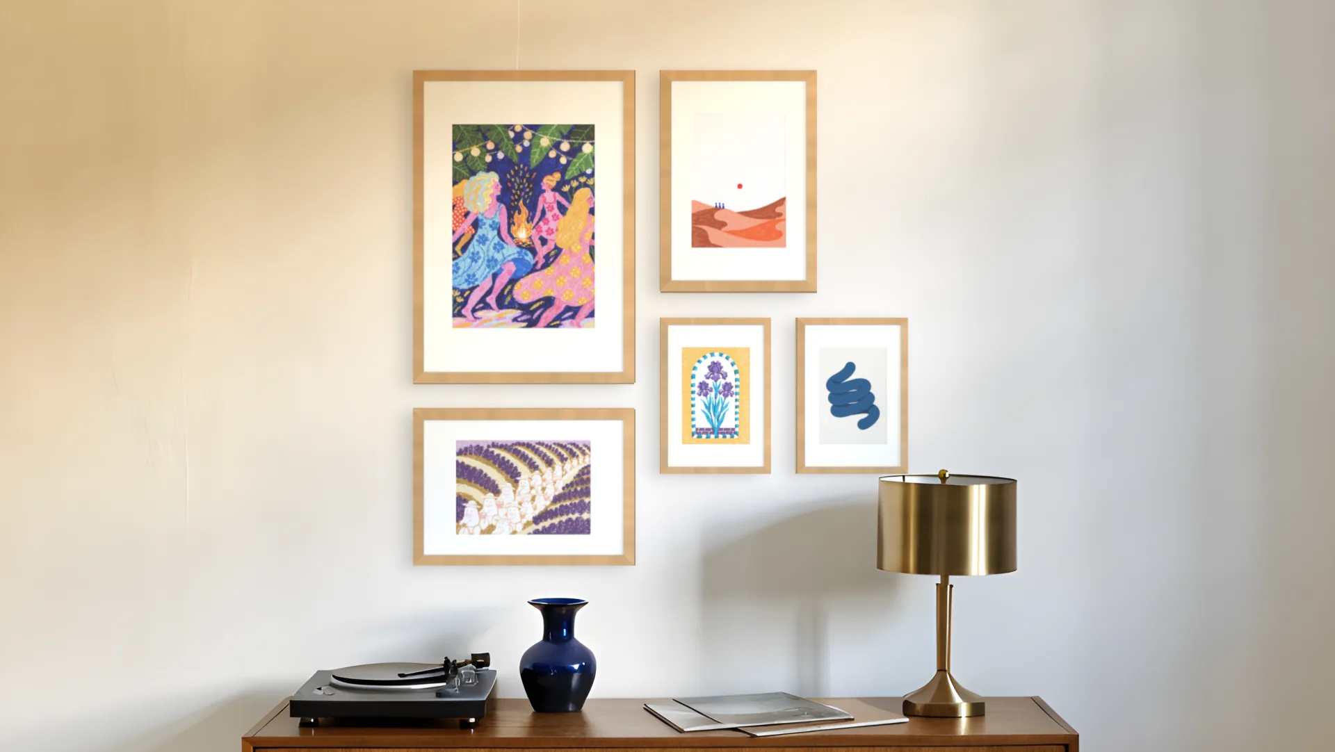 Living room gallery wall idea: five prints in oak frames in an asymmetric layout above a sideboard in a living room.