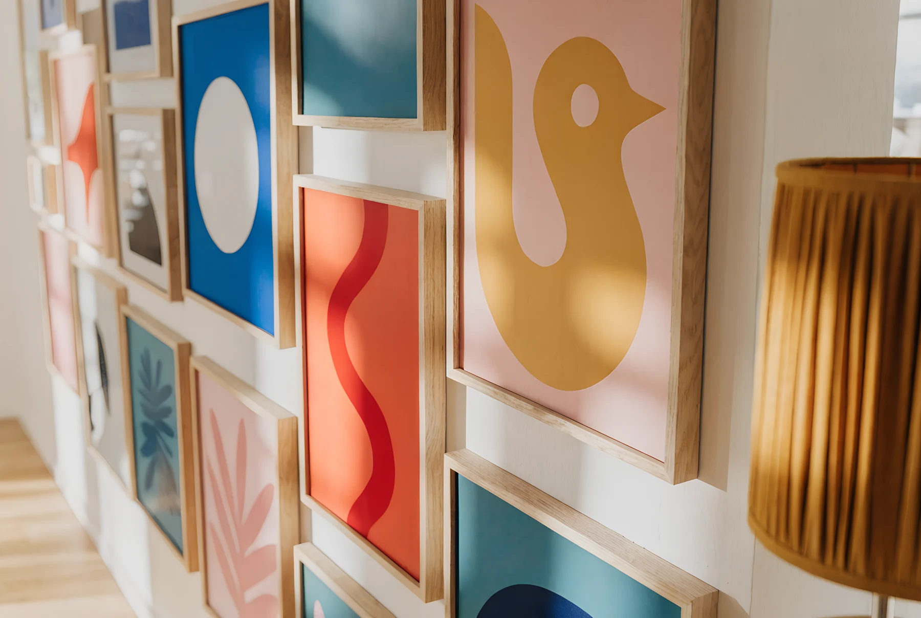A close view of a salon-style gallery wall of tightly hung colourful prints