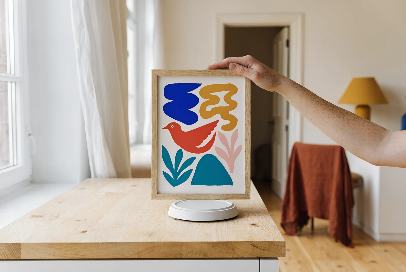A framed colourful print weighed on kitchen scales before hanging