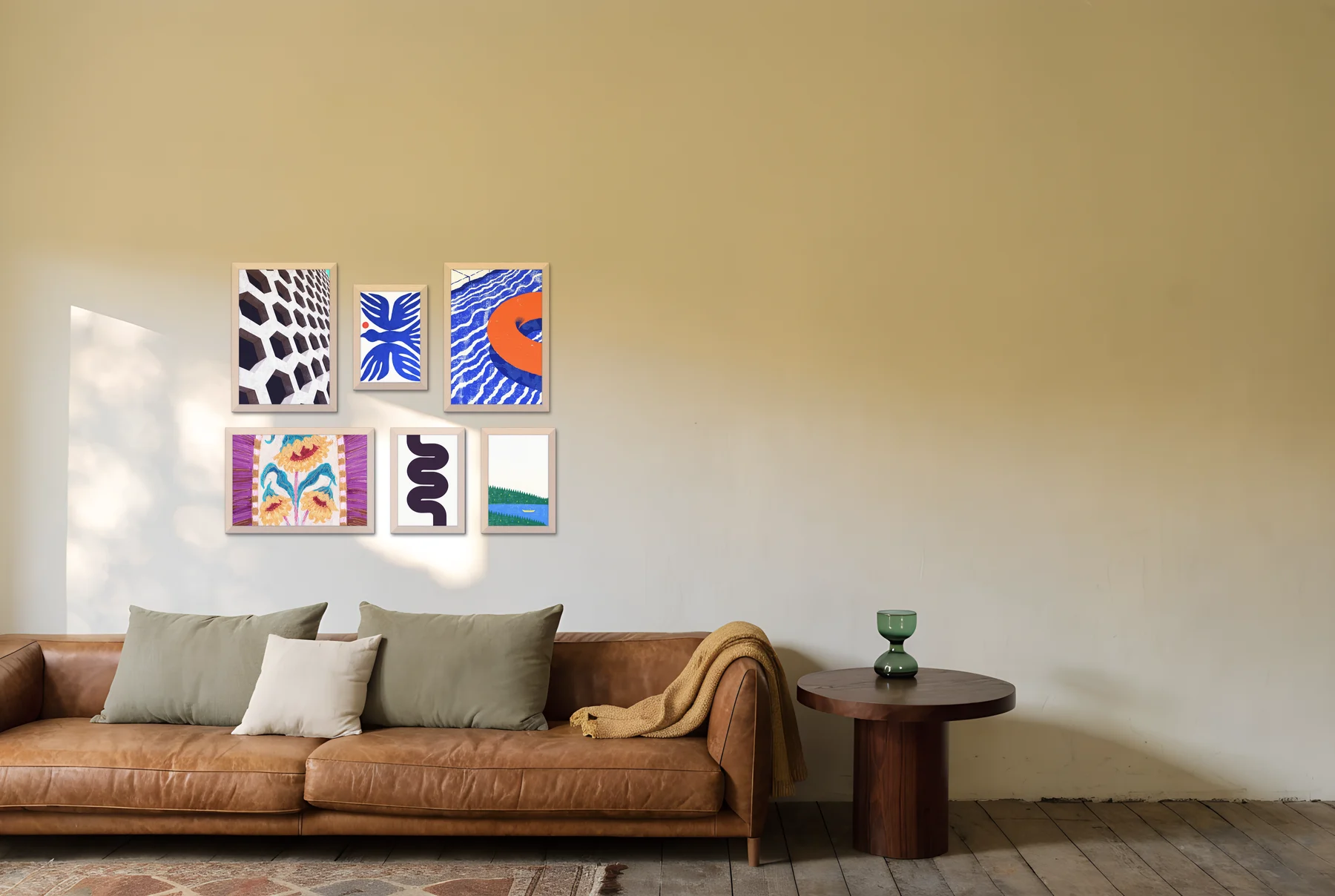 A six-frame salon gallery wall hung above a tan leather sofa