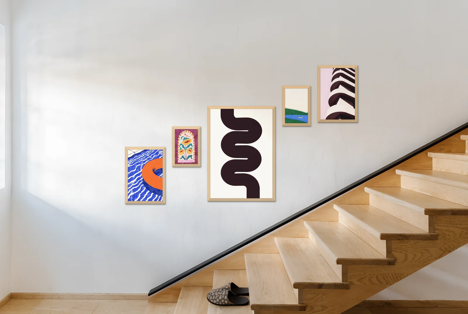 A gallery of five frames rising with the stairs on a staircase wall