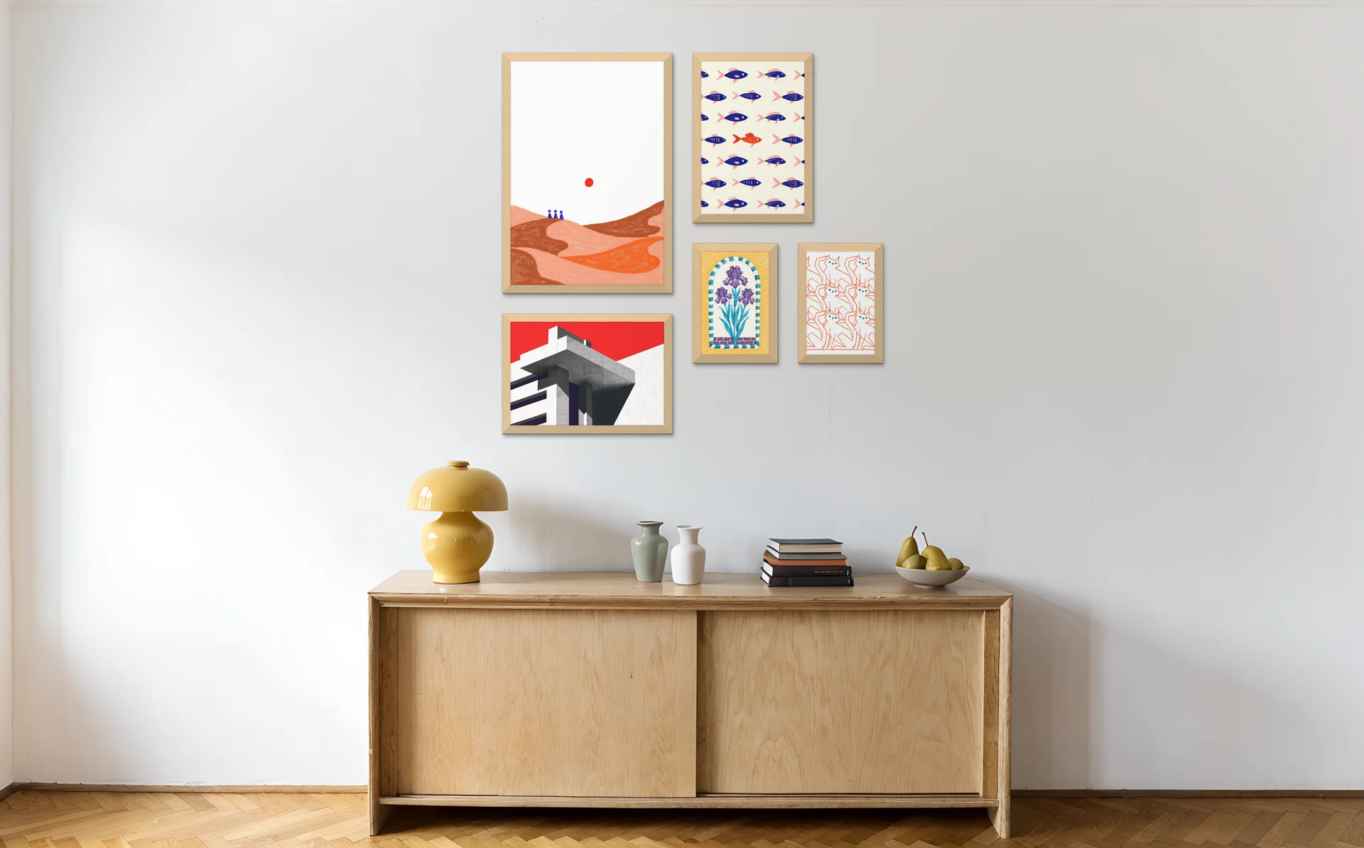 The asymmetric gallery wall layout above a sideboard with a yellow lamp