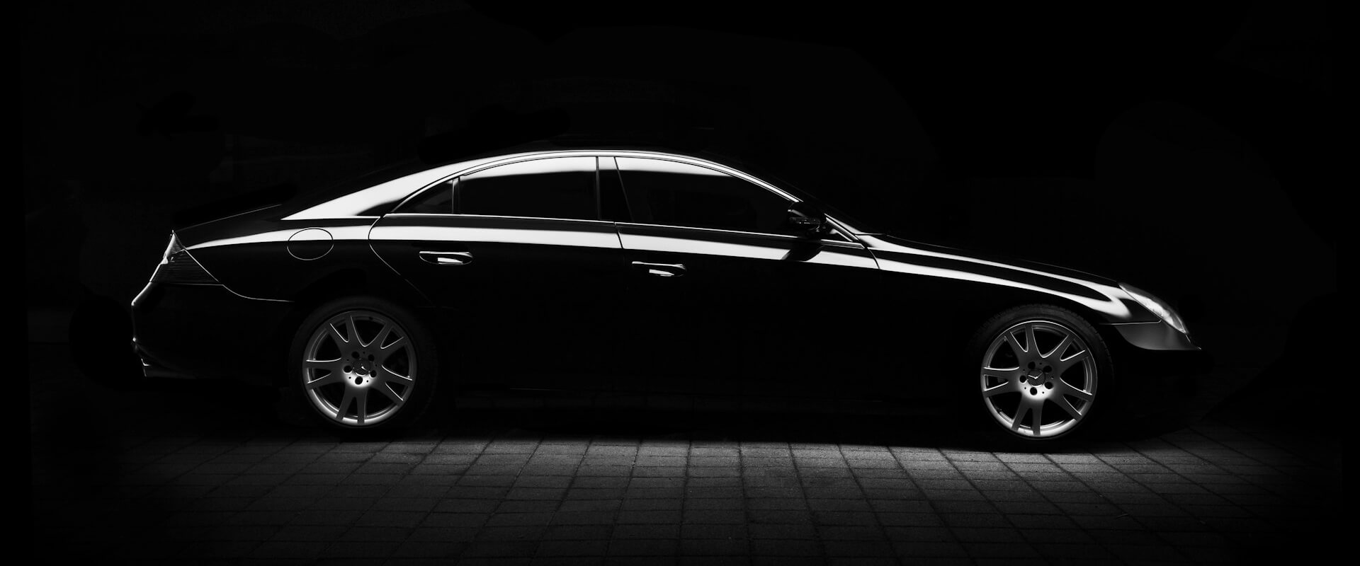 Chauffeur von Bey Limousine Service öffnet die Tür einer schwarzen Limousine