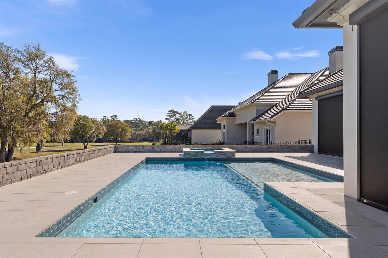 Rectangular pool and raised spa overlooking a golf course at a Central Florida home