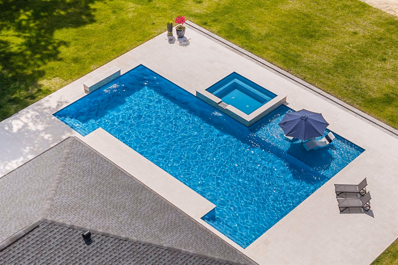 Aerial view of a rectangular pool and spa beside a green lawn