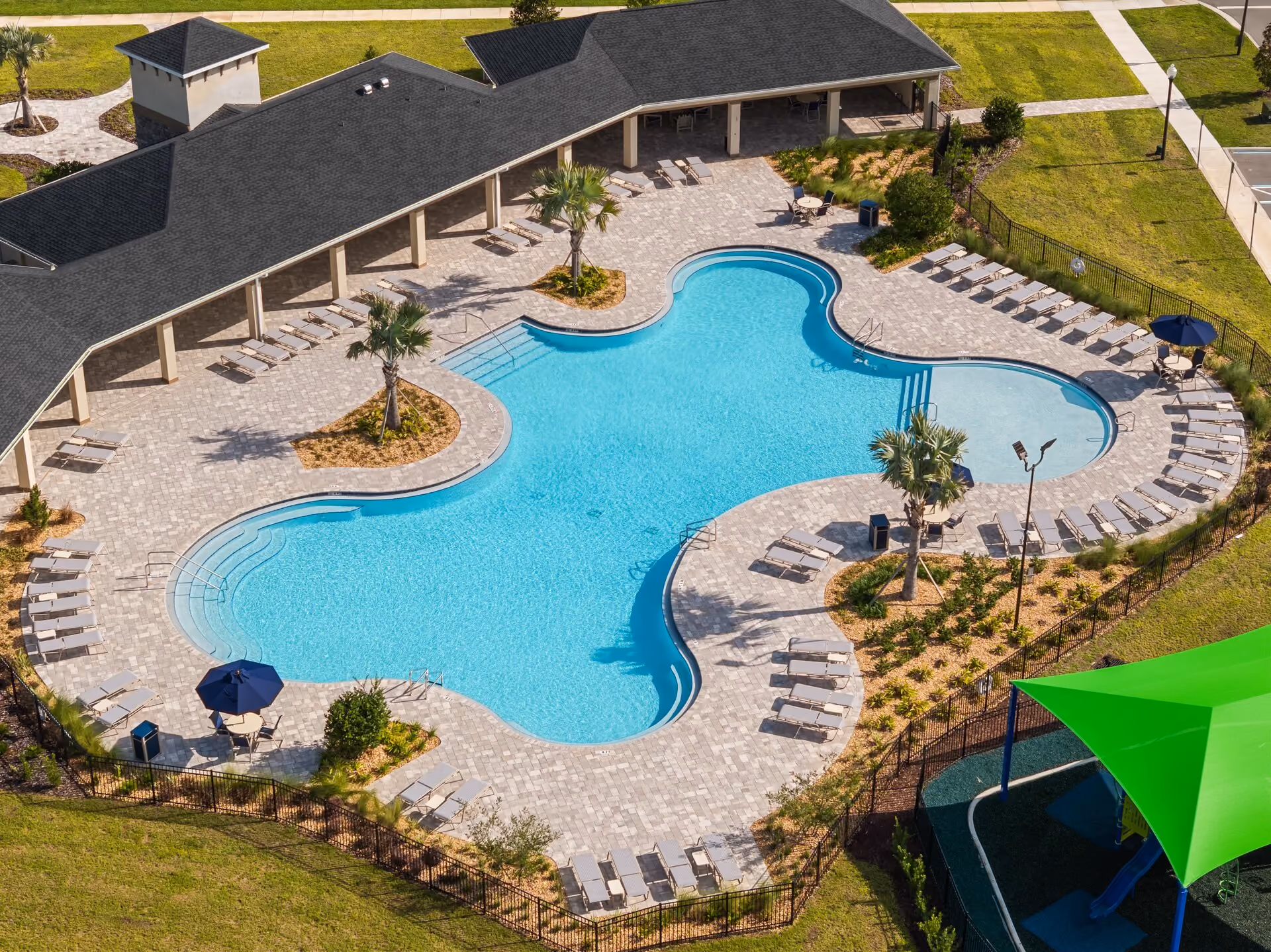 Resort-style freeform community pool with lounge seating