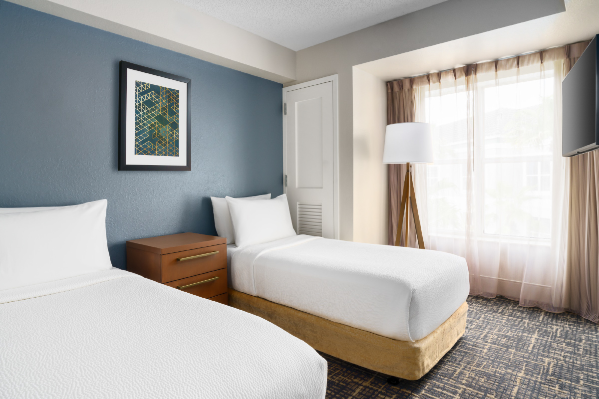 two beds in hotel room with art on wall