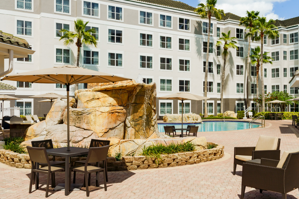 outdoor waterfall in courtyard next to pool of hotel