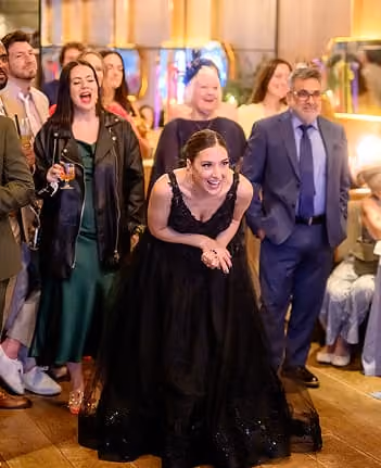 Wedding guests laughing together over drinks in the restaurant.