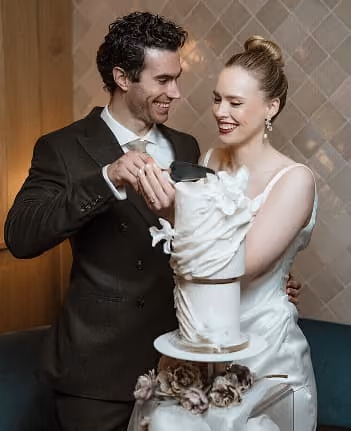A couple cutting their wedding cake together.