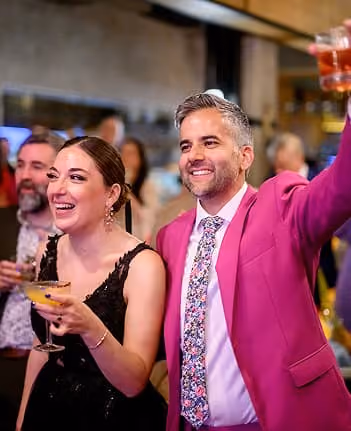 A couple celebrating with guests at their wedding reception.