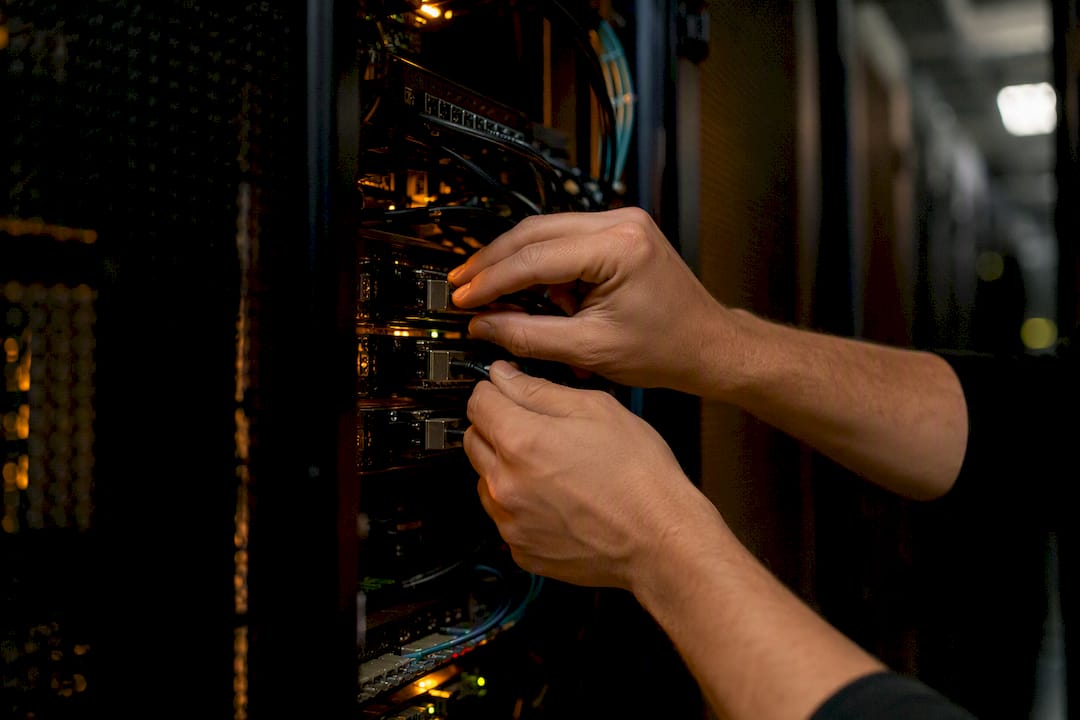 Hands connecting data cables in fintech center