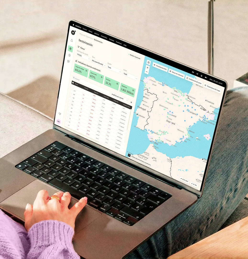 Personne utilisant un ordinateur portable affichant une carte de l'Espagne et des données analytiques.