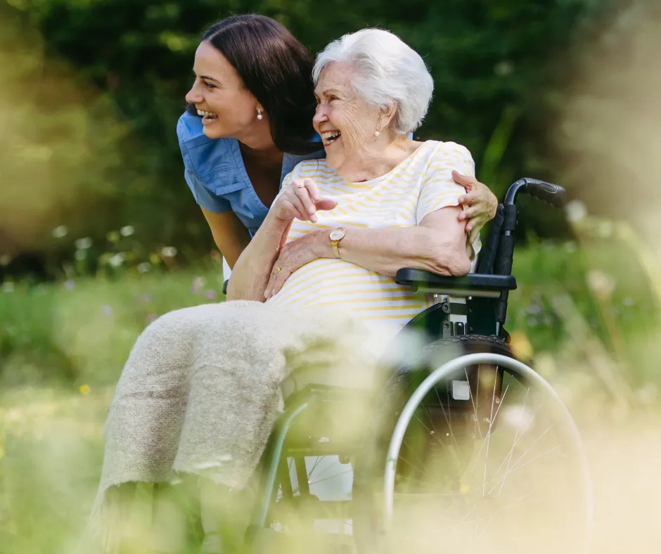 A caregiver and resident enjoying a sunlit garden together