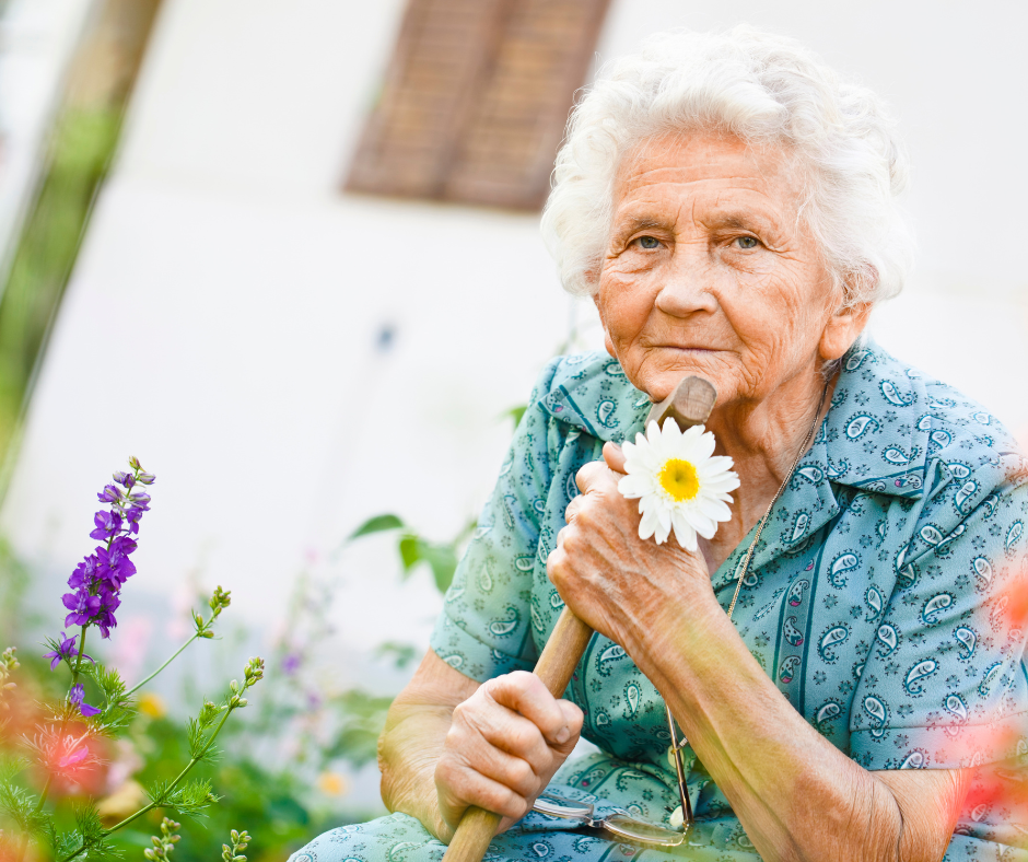 A resident holding a daisy in the garden