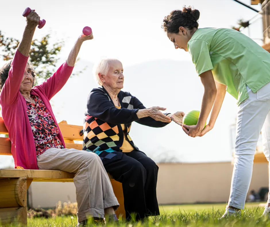 A caregiver leading residents in a gentle outdoor exercise session