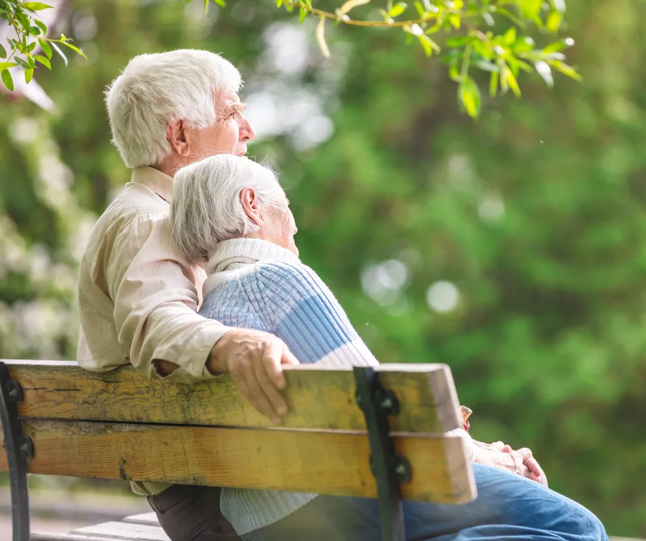 A couple resting together on a garden bench