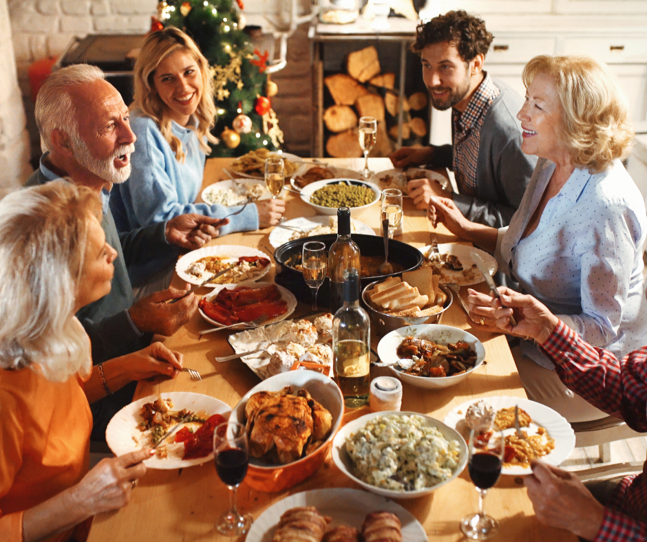 Family sharing a festive holiday dinner together around a candlelit table