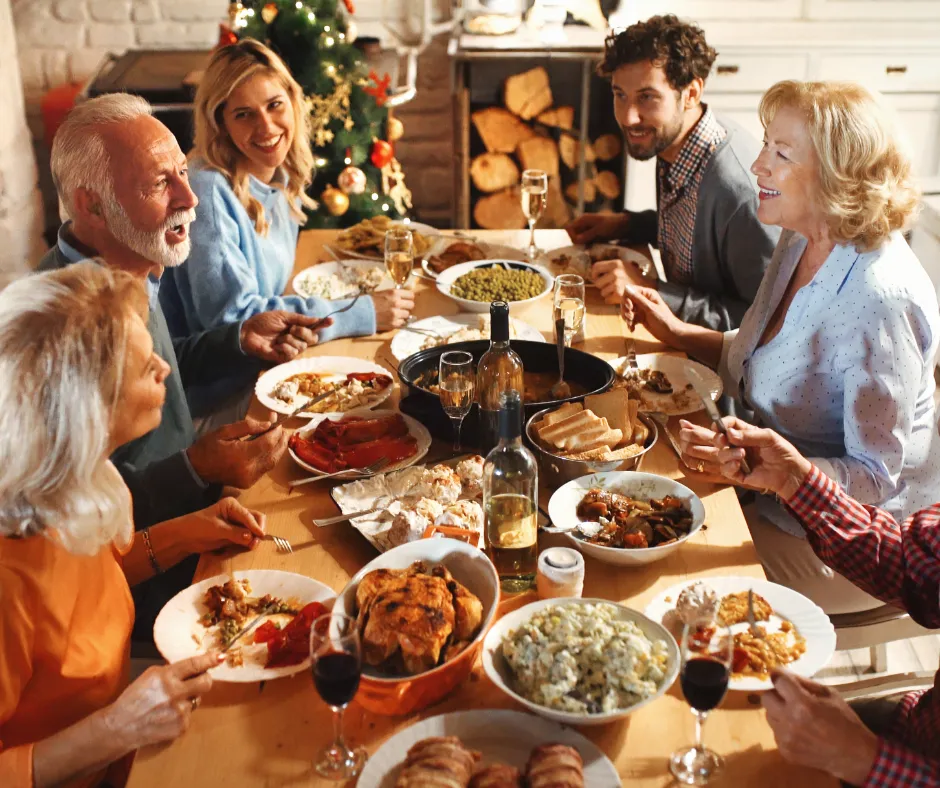 Family sharing a festive holiday dinner together around a candlelit table