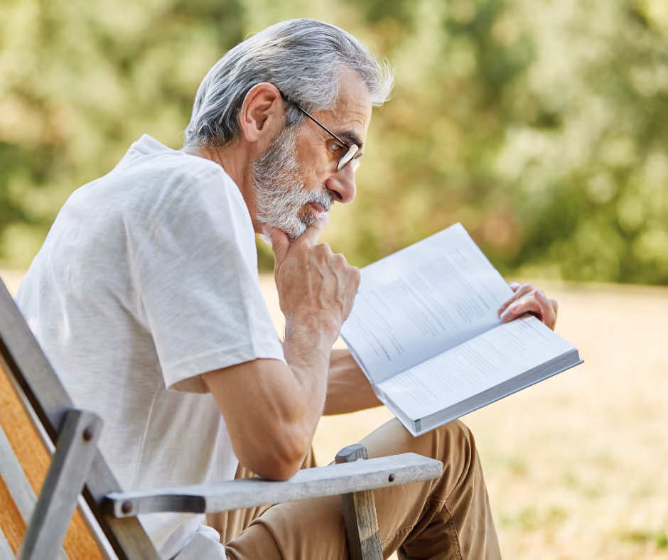 A resident enjoying a book outdoors at HSL Gilbert