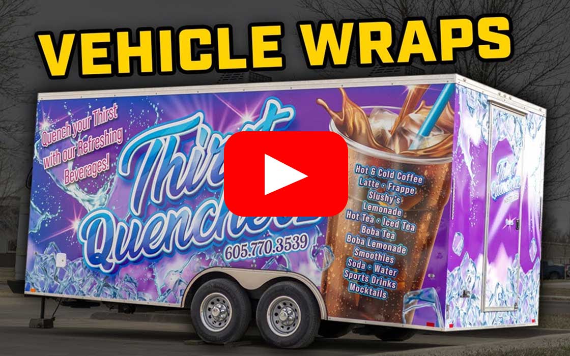 Trailer with a colorful vehicle wrap advertising Thirst Quencher beverages, listing drinks like hot & cold coffee, latte, frappe, smoothies, and sports drinks.
