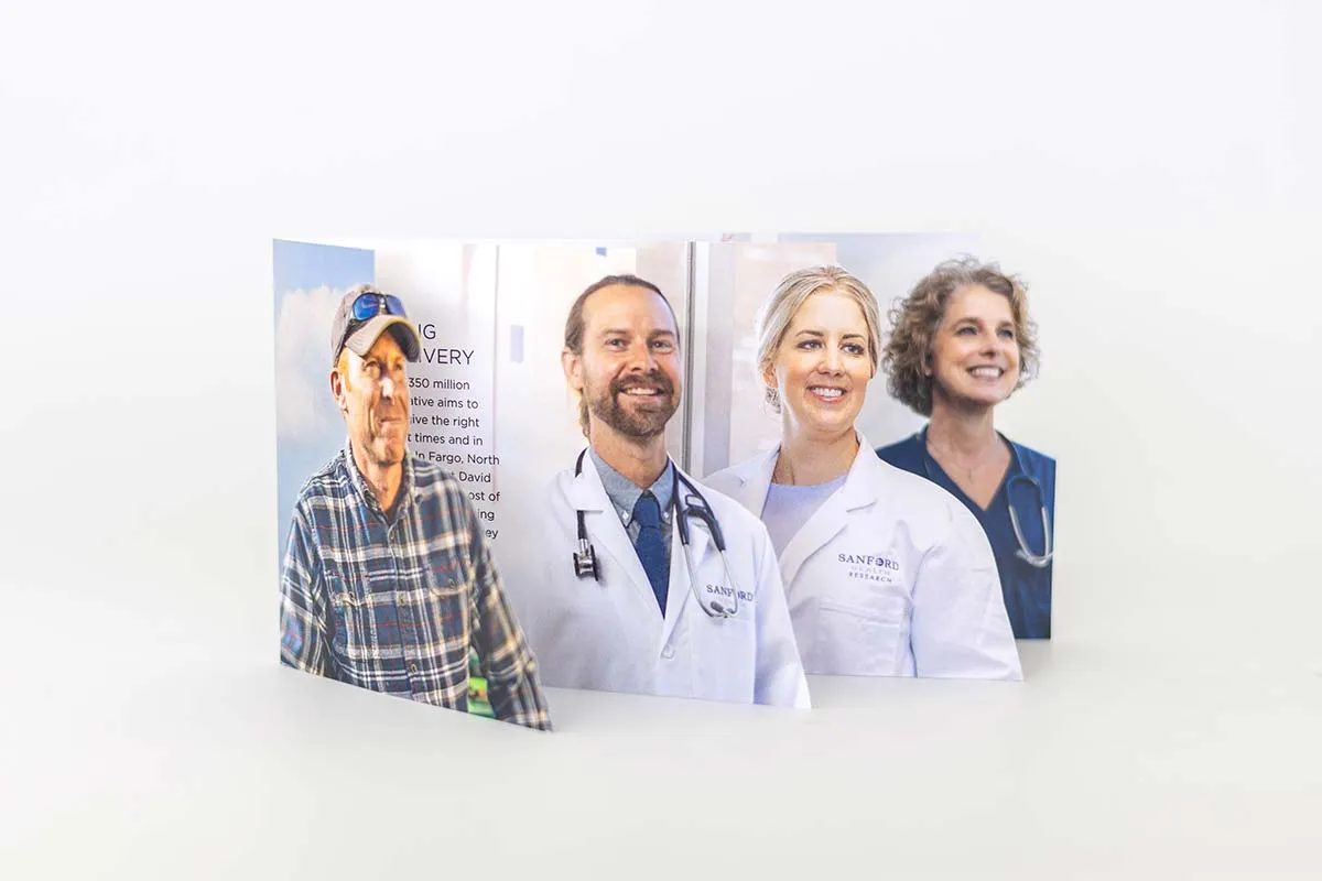 Tri-fold brochure featuring portraits of three healthcare professionals in white coats and one man in a plaid shirt and baseball cap standing outdoors.