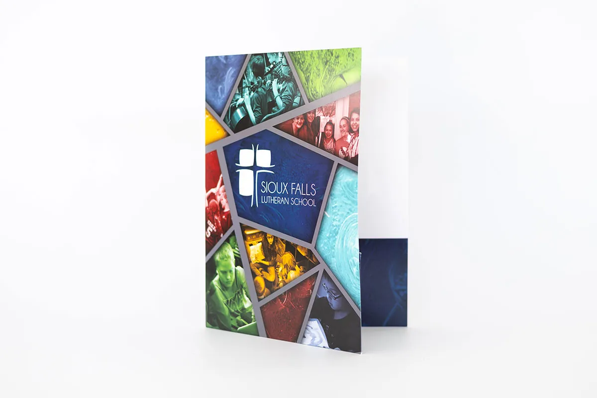 Promotional folder standing upright with a mosaic design featuring photos of students and activities around a central blue panel displaying the Sioux Falls Lutheran School logo with a white cross and text.