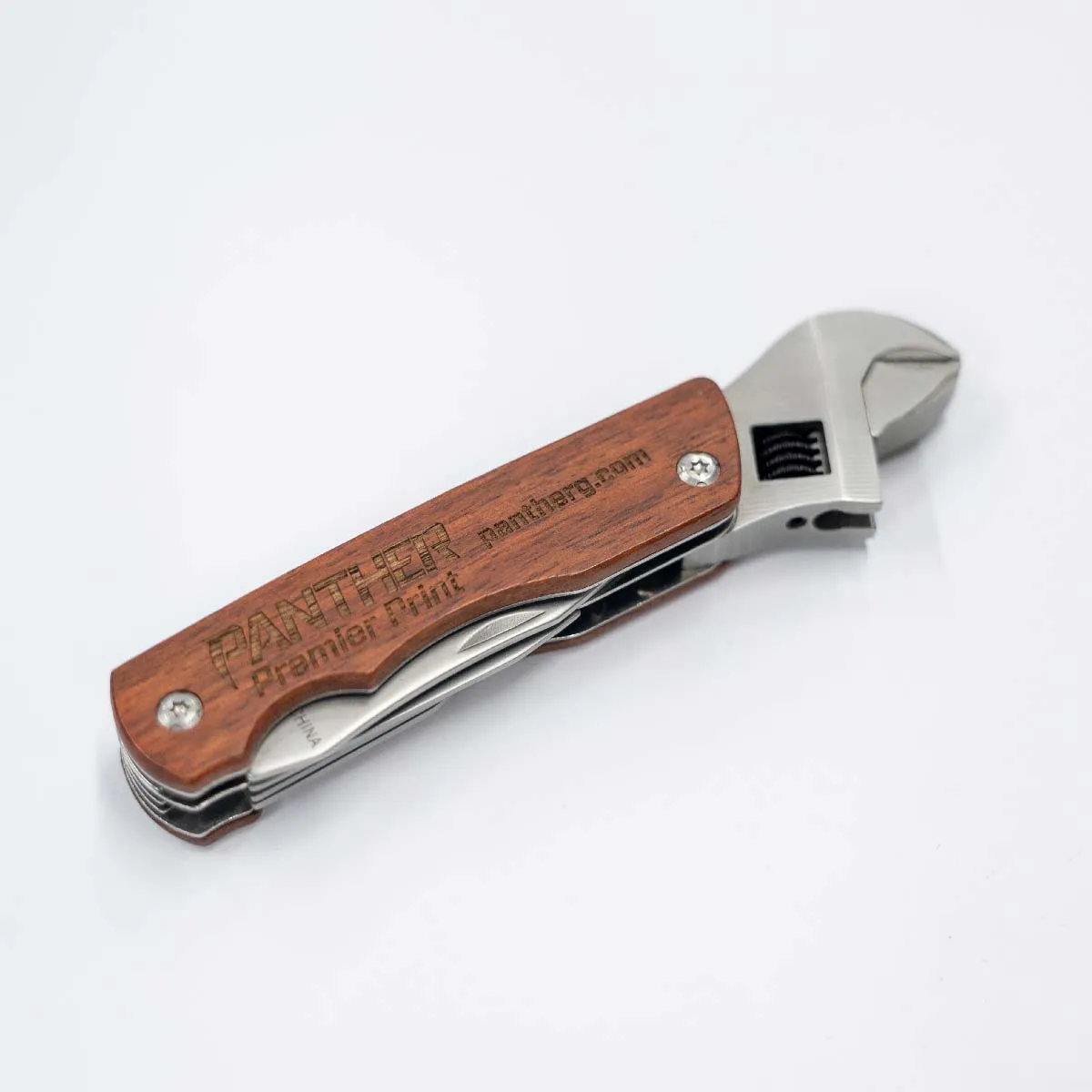 Multi-tool with wooden handle engraved with "PANTHER Premier Print panthergp.com" and an adjustable wrench head made of metal.