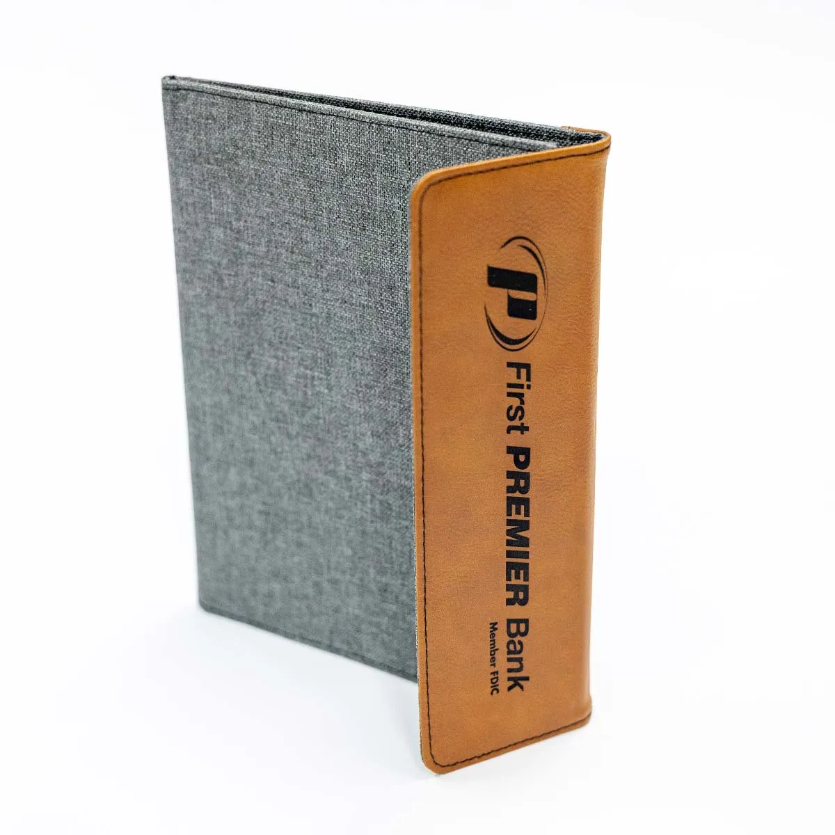 Gray fabric folder with a brown leather spine featuring the logo and text 'First PREMIER Bank Member FDIC'.