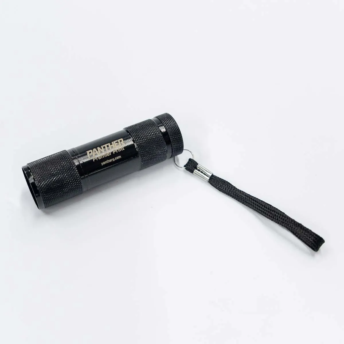 Small black cylindrical flashlight labeled 'PANTHER Premier Print' with textured grip and attached black wrist strap on a white background.