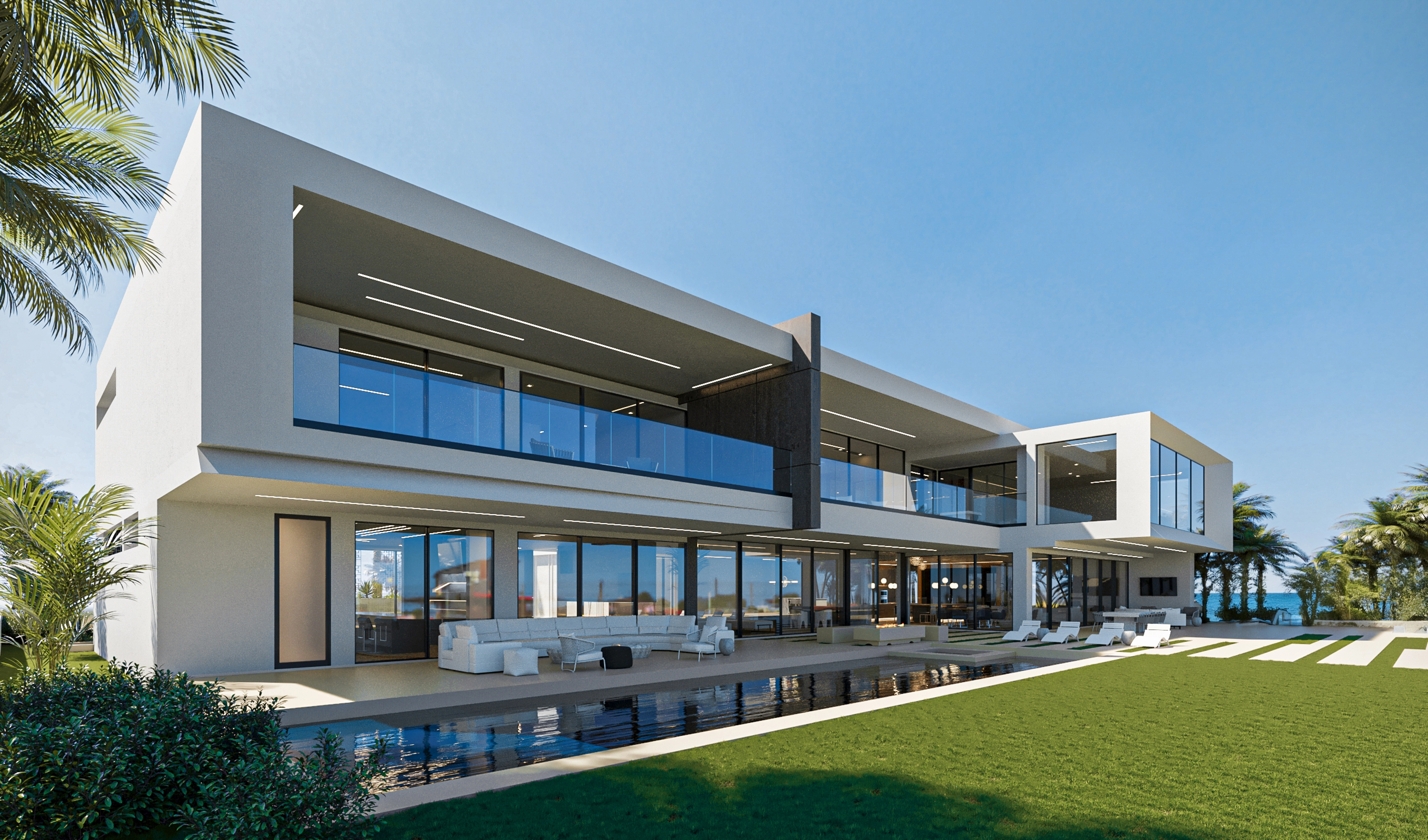 Modern two-story house with large glass windows, outdoor seating, pool, and lawn under a clear sky.