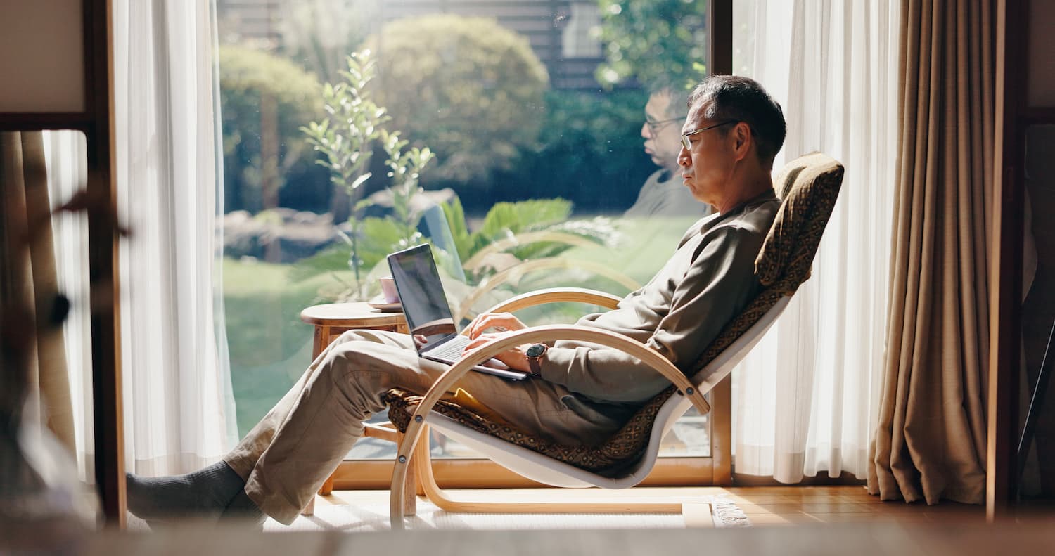 A man works on his laptop while sitting comfortably, enjoying a relaxed indoor atmosphere.